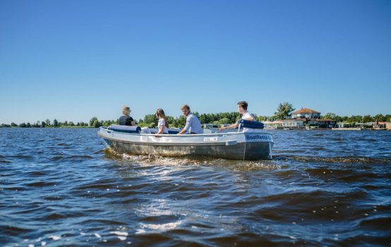 Family enjoying electric boat ride on Giethoorn lake