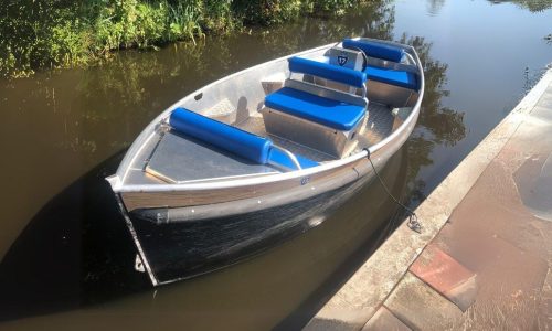 Electric sloops moored along Giethoorn canal shore